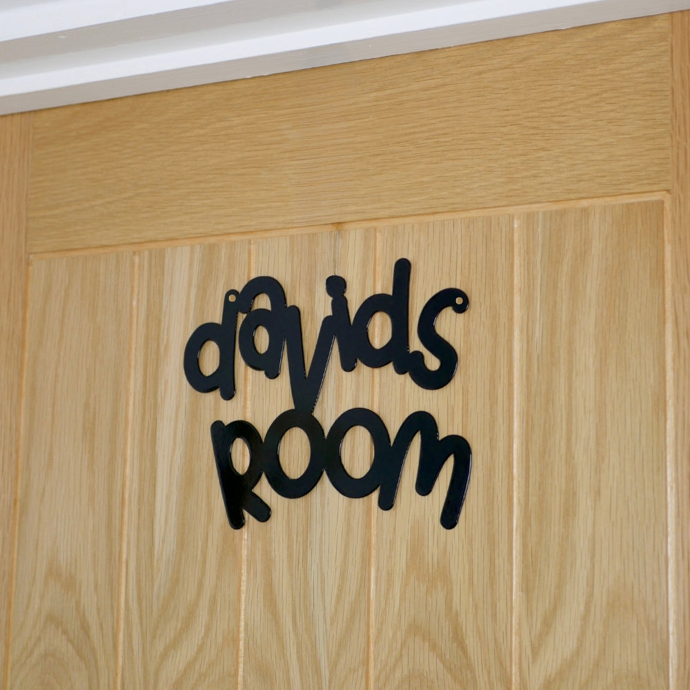 A side view of a black personalised name sign reading davids room