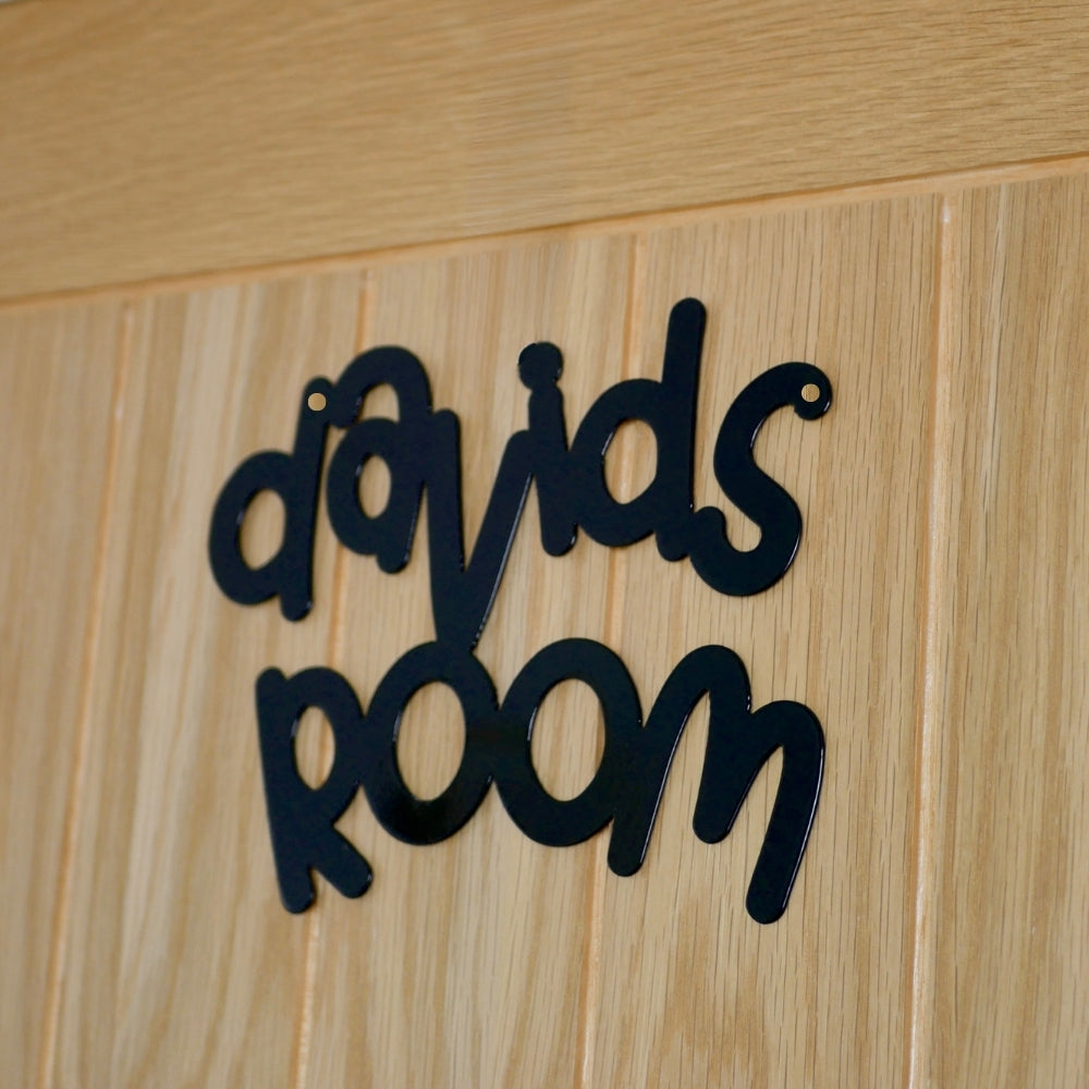A close up of a black personalised name sign reading davids room