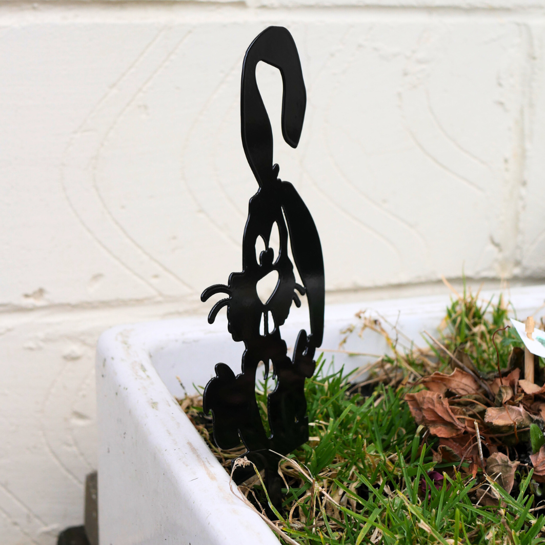 A side view of a metal black garden stake in the shape of a bunny rabbit.