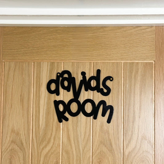 A black personalised name sign reading davids room