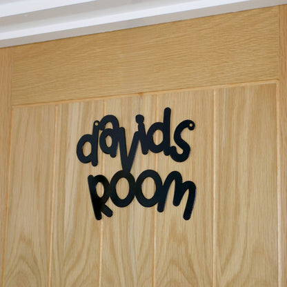 A side view of a black personalised name sign reading davids room