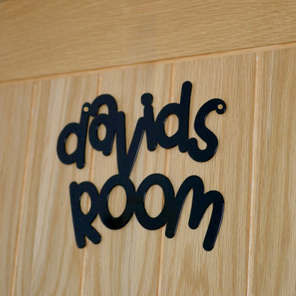A close up of a black personalised name sign reading davids room