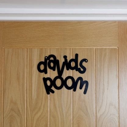 A black personalised name sign reading davids room