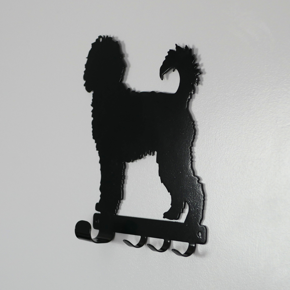 A side view photo of a cockerpoo dog shaped black metal dog lead and key rack.