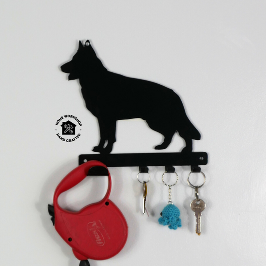 A german shepard shaped metal black dog lead and key rack. Hanging from the four hooks are a dog lead, keyring, and two keys.