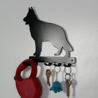 A german shepard shaped metal black dog lead and key rack. Hanging from the four hooks are a dog lead, keyring, and two keys.