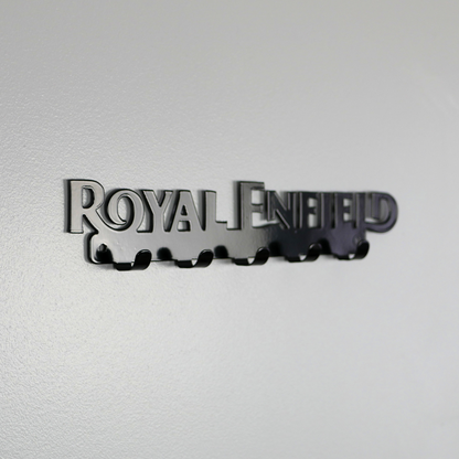 A left side view of a black metal key rack in the shape of the Royal Enfield logo, it has 5 hooks.